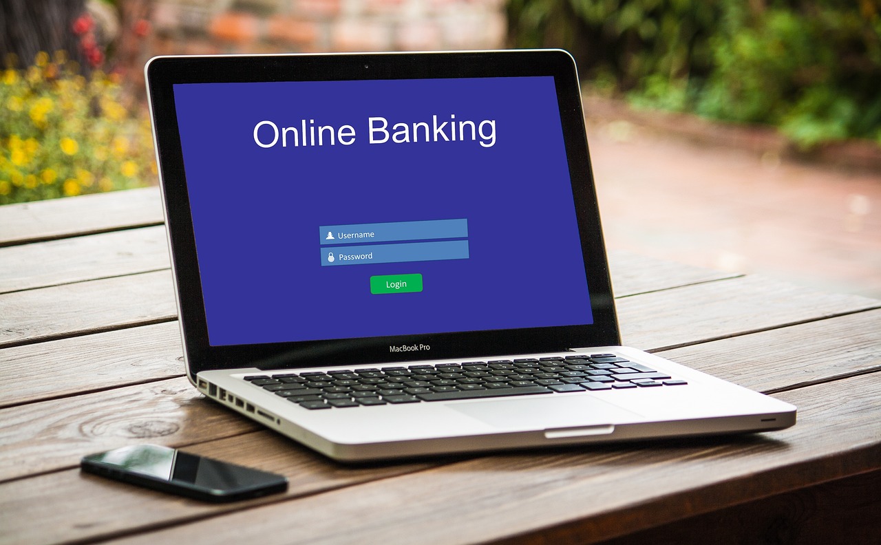 A laptop displaying an online banking login screen, representing digital financial management and savings tracking
